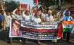 Dalit activists and supporters hold placards and raise