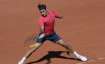 Switzerland's Roger Federer plays a return to Uzbekistan's