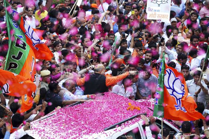 BJP President Amit Shah is showered with flower petals as
